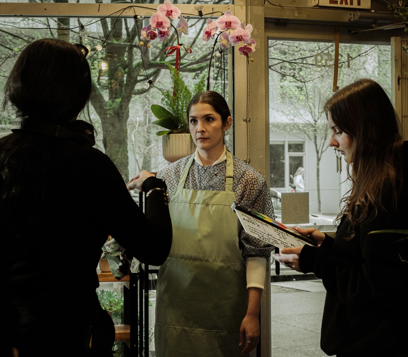 Production still: a florist in an apron in a flower shop
