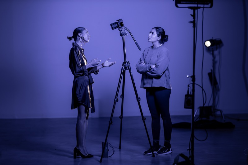 Directing an interview in a violet-lit studio